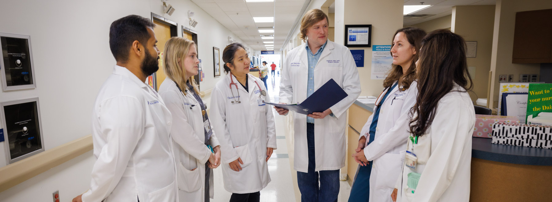 A group of hospitalists convene for a patient care discussion.